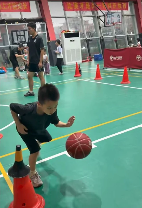 小球员在标志桶之间练习持球移动